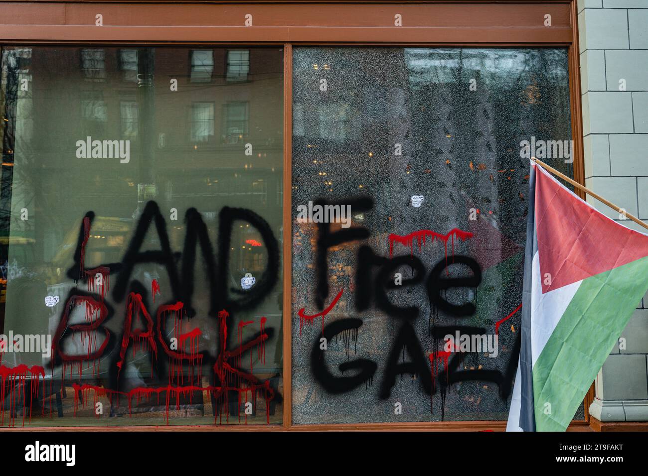 Graffiti auf kaputten Starbucks-Fenstern mit Nachrichten, die während der Demonstration „Free Gaza“ und „Land Back“ lauteten. Eine Versammlung pro-palästinensischer Anhänger fand im First Starbucks Reserve Roastery in Seattles lebhaftem Capitol Hill statt. Bei der Veranstaltung, die durch Demonstrationen gekennzeichnet war, wurden verschiedene Schilder und Botschaften deutlich sichtbar angezeigt. Unter den zahlreichen Schildern, die von den Demonstranten getragen wurden, lautete eines: "Steht mit Palästina! Beende die Besatzung jetzt!“ Während andere verkündeten: "Palästina wird frei sein!" Stockfoto