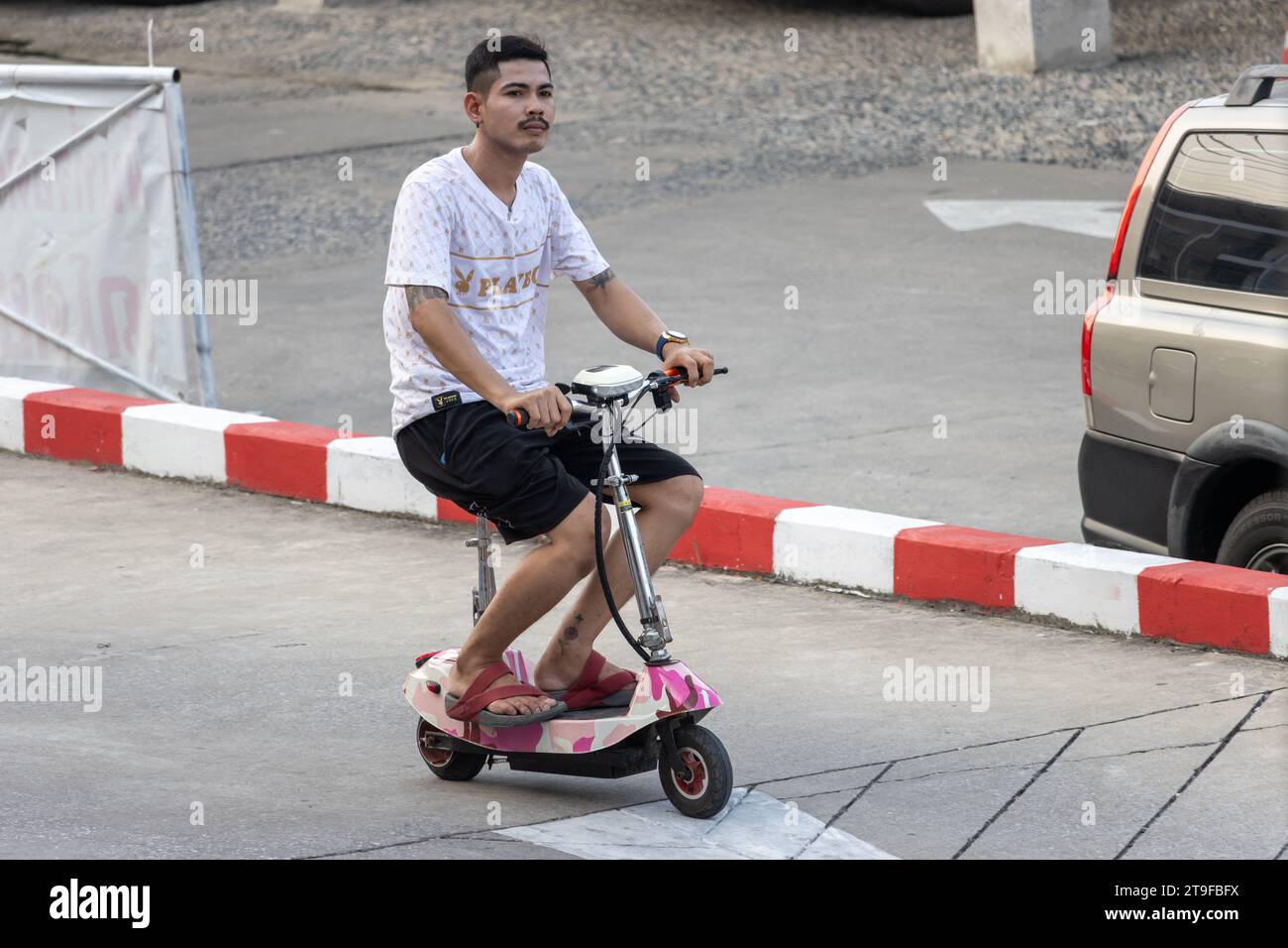 SAMUT PRAKAN, THAILAND, 03. November 2023, Ein junger Mann fährt einen Elektroroller Stockfoto