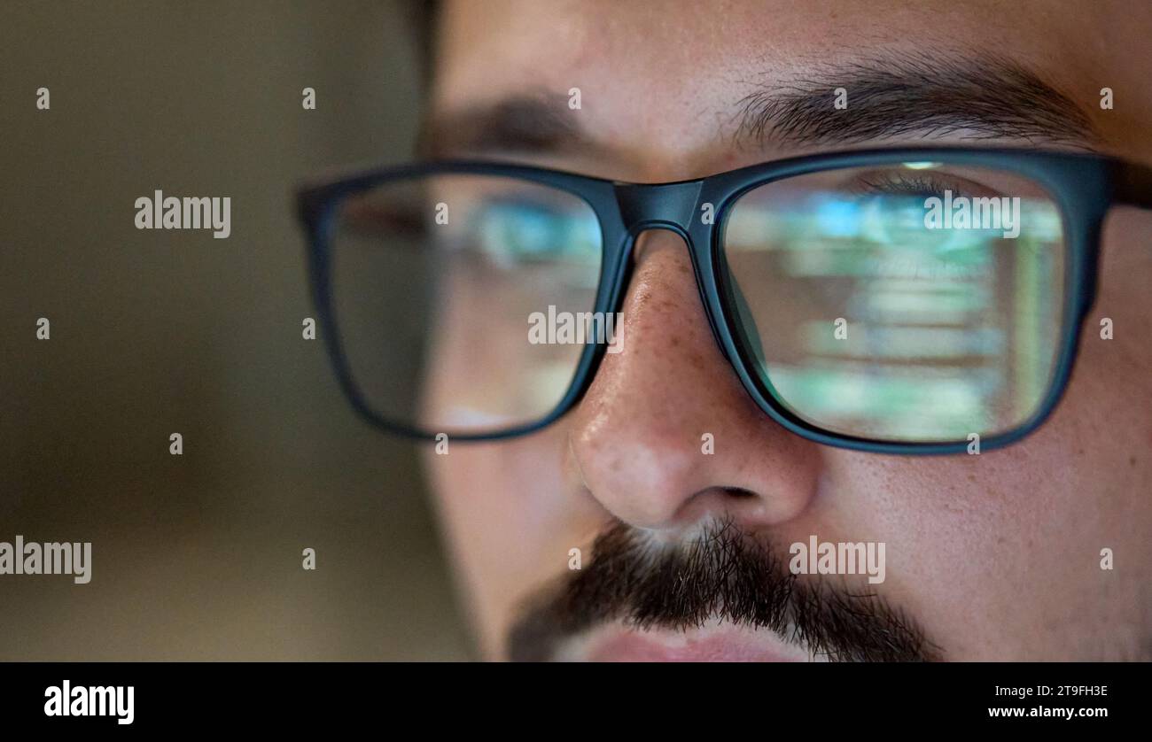 Geschäftsmann, der eine Brille mit Reflexion trägt, indem er Computer-Entwicklungscode verwendet. Stockfoto