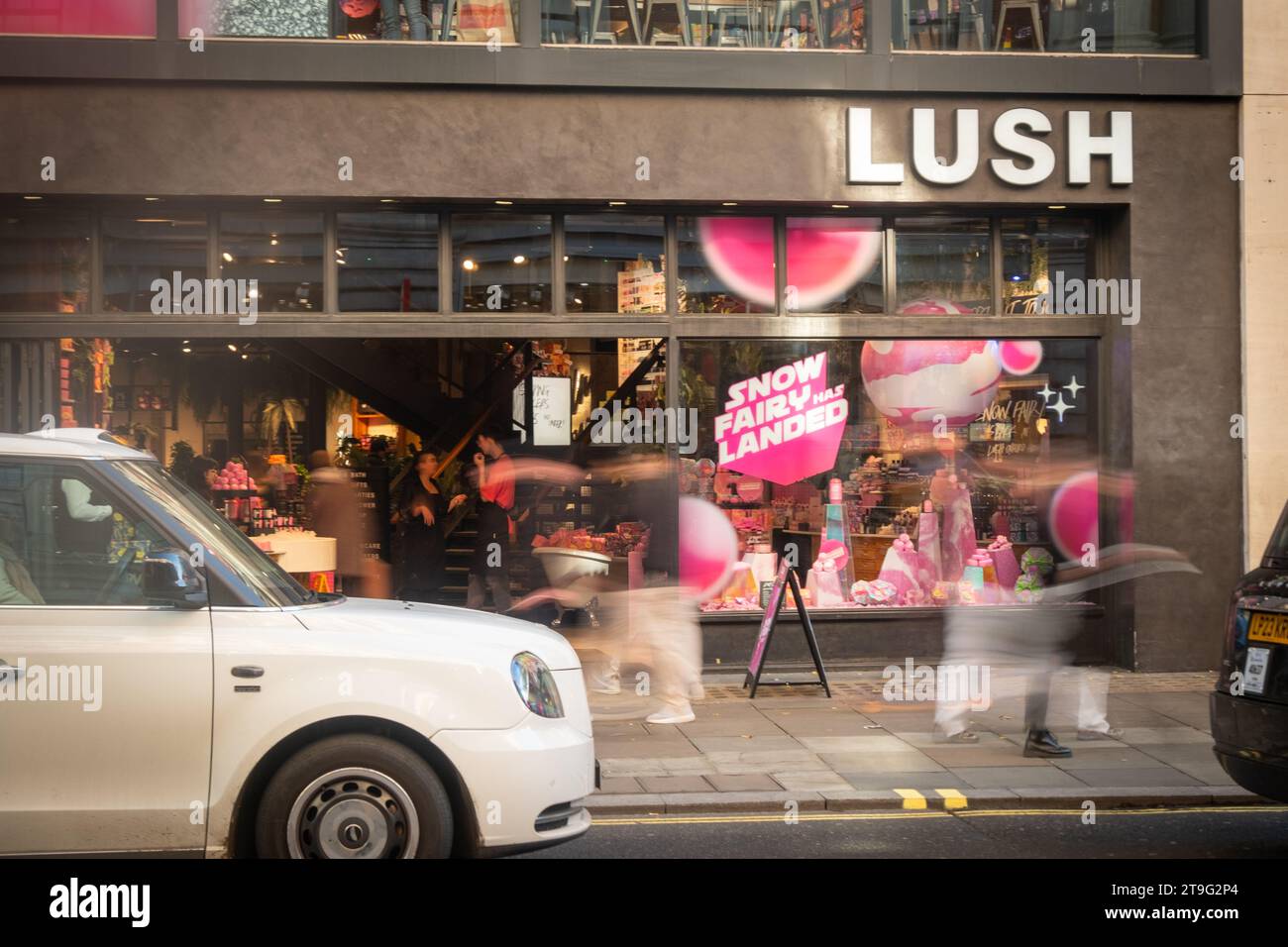 LONDON – 23. NOVEMBER 2023: Üppige Kosmetik- und Schönheitsgeschäfte und bewegungsunscharfe Einkäufer in der Oxford Street, einem Wahrzeichen des Einzelhandels Stockfoto