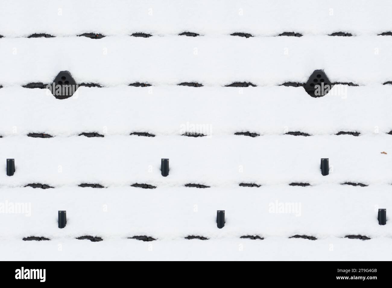 Abstrakte Fotografie von schwarzem Dach mit Erstschnee. Eiskaltes Wetter. Stockfoto