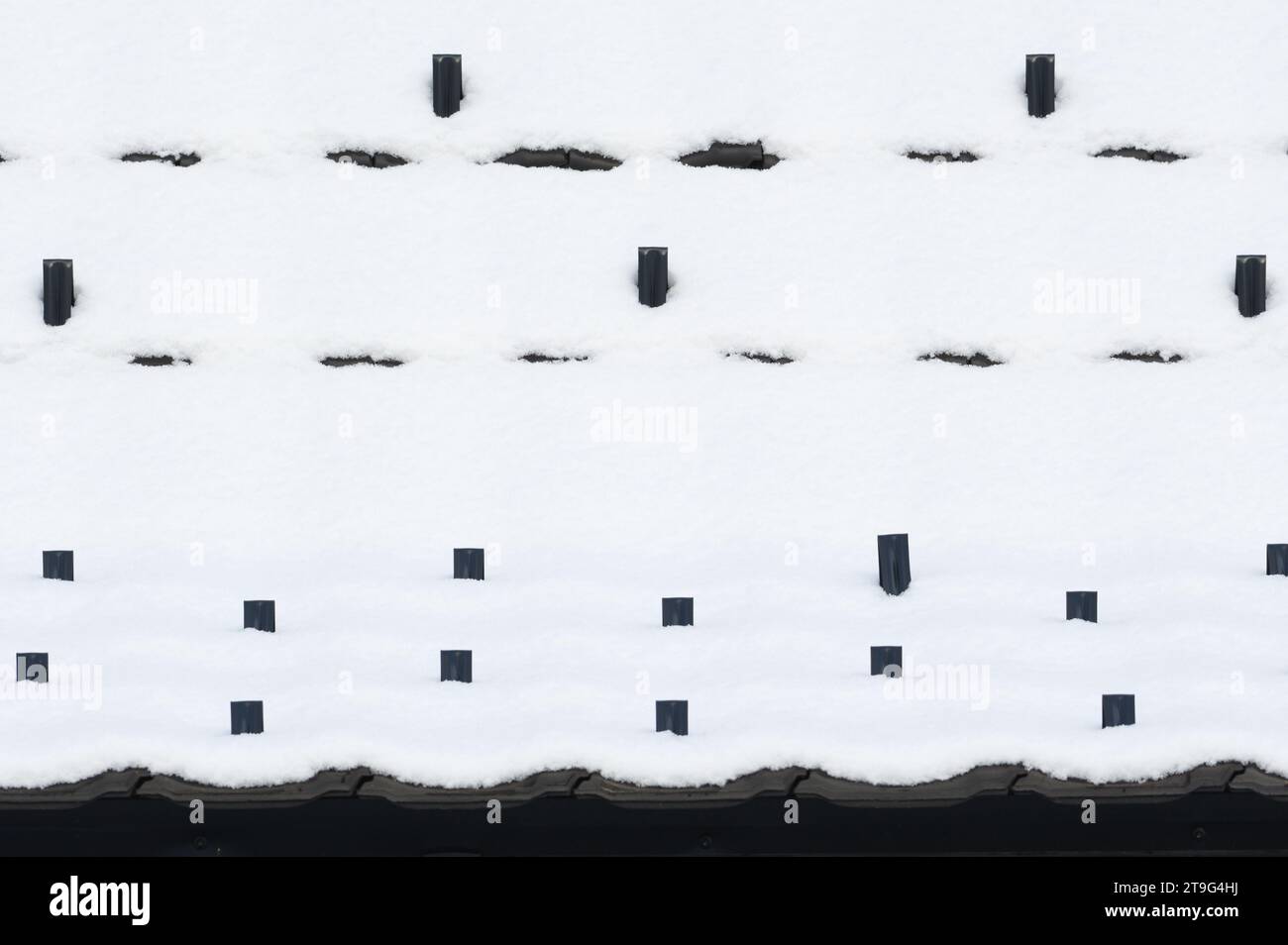 Abstrakte Fotografie von schwarzem Dach mit Erstschnee. Eiskaltes Wetter. Stockfoto