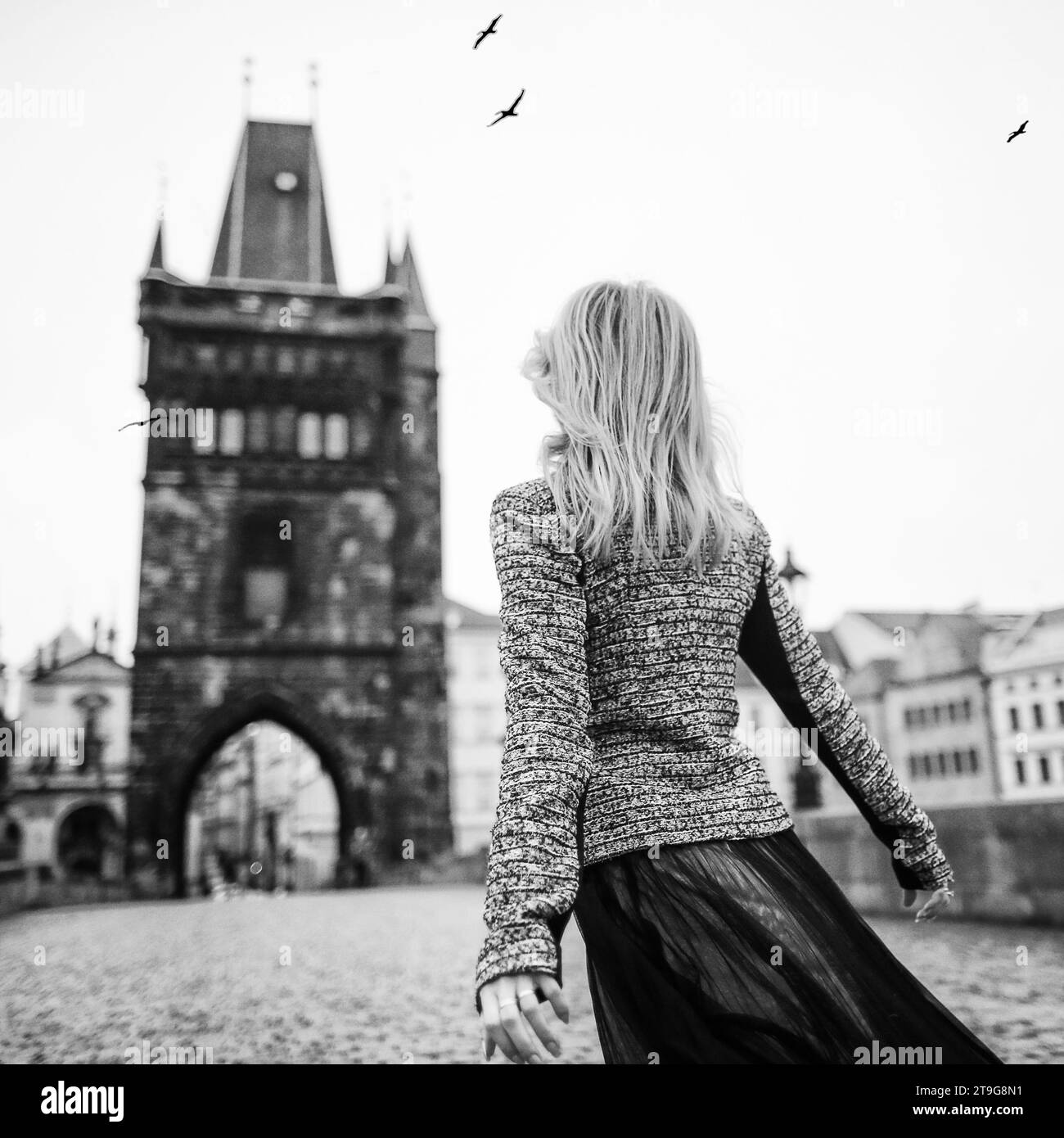 Junge Schönheitsfrau, die in der Altstadt von Prag an der Karlsbrücke spaziert Stockfoto