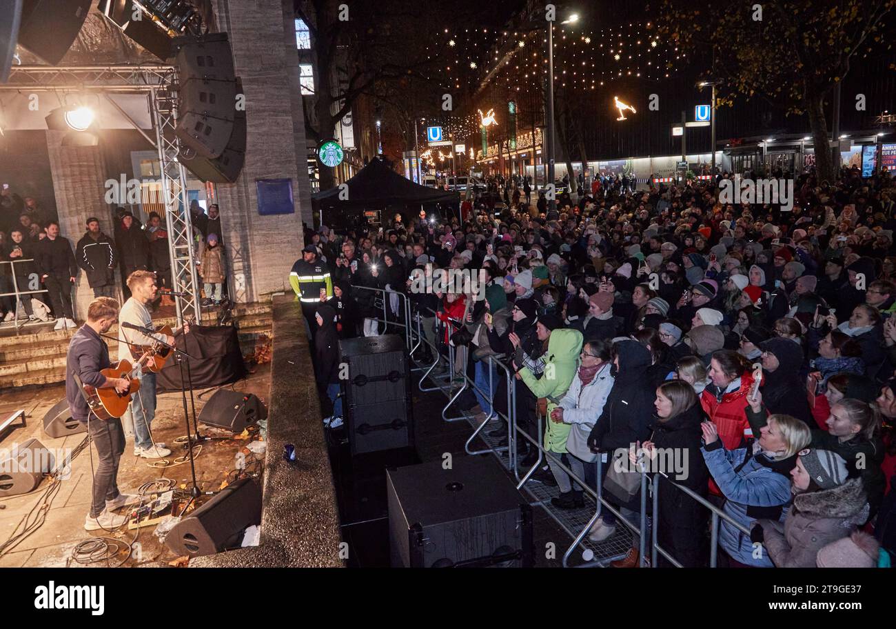 Hamburg, Deutschland. November 2023. Kris Hünecke (l), Gitarrist, und Johannes Strate, Sänger der Band Revolverheld, stehen auf einer Terrasse in der Mönckebergstraße und geben ein Überraschungskonzert. Quelle: Georg Wendt/dpa/Alamy Live News Stockfoto