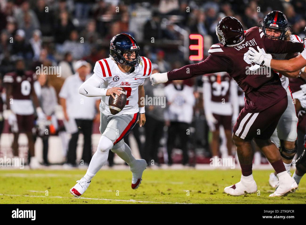 Starkville, Mississippi, USA. November 2023. 11/23/23 - Starkville, MS - Ole Miss Rebels Quarterback JAXSON DART (2) wird fast von Mississippi State Bulldogs Defensive Tackle JADEN CRUMEDY (94) im Davis Wade Stadium in Starkville, Mississippi.Zuma Press (Kreditbild: © Hunter Cone/ZUMA Press Wire) NUR REDAKTIONELLE VERWENDUNG! Nicht für kommerzielle ZWECKE! Stockfoto