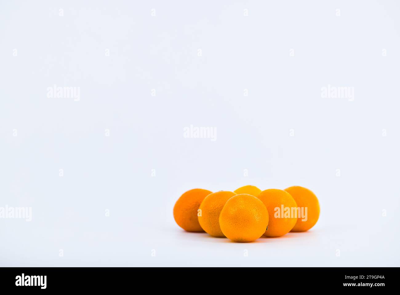 Eine entzückende Komposition, die die Frische von Mandarinen vor einem sauberen weißen Hintergrund einfängt. Stockfoto
