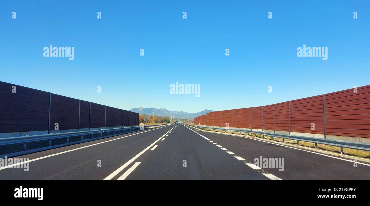 Schalldämmende Lärmschutzwand auf der Autobahn zum Schutz vor Lärmemissionen von Fahrzeugen in der Nähe des Stadtzentrums Stockfoto