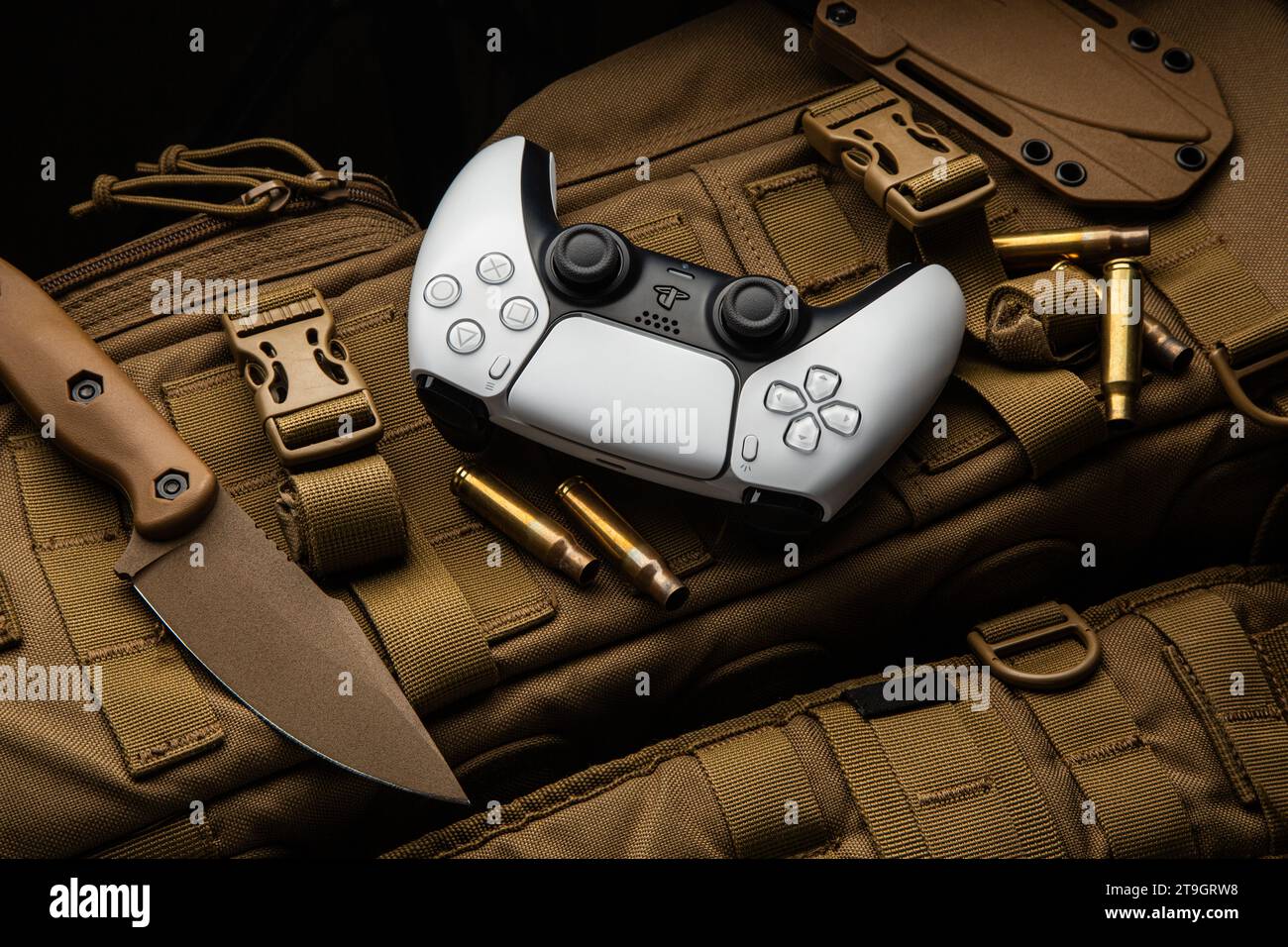 1. September 2021, Odessa, Ukraine. Weißer neuer Gamepad-Dualsense für PlayStation 5 auf einem modernen, wüstenfarbenen Militärrucksack. Militärische Messer und Muscheln Stockfoto