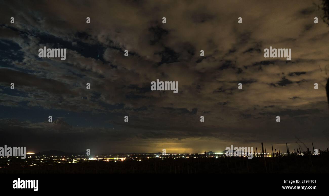 Tucson City Lichter von einem Felsen mit Blick auf die Wüste bei Nacht. Schauen Sie genau hin und Sie werden den Kometen NEOWISE am klaren Himmel sehen. Stockfoto