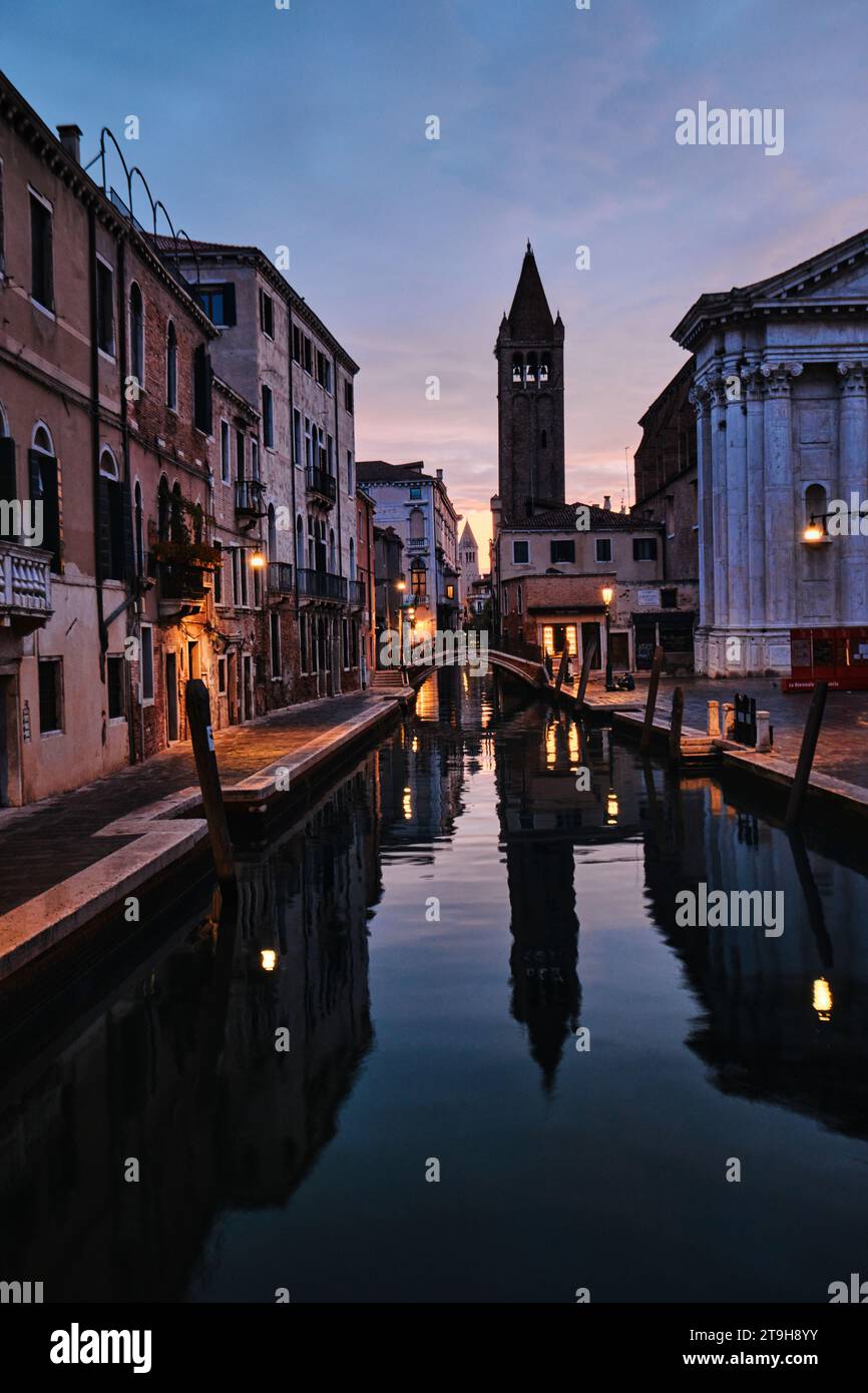 Venedig, Italien - 9. November 2023: Glockenturm der Chiesa di San Barnaba und schmaler Kanal in Venedig bei Sonnenaufgang Stockfoto
