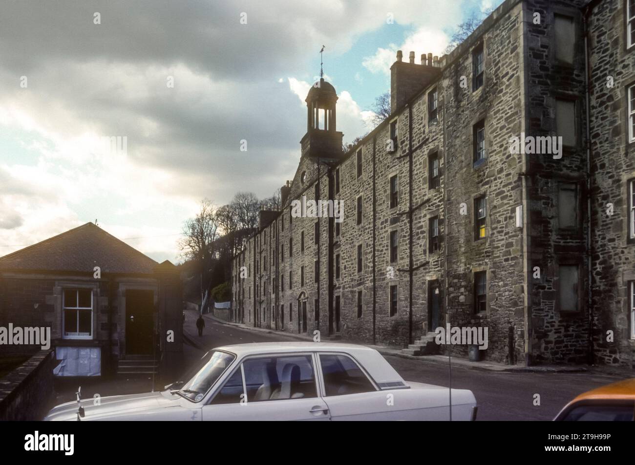 1977 Archivfoto der New Lanark Mill Welterbestätte in South Lanarkshire, Schottland. Das Unternehmen wurde 1785 von David Dale in Partnerschaft mit Richard Arkwright gegründet und war in einer Zeit der Partnerschaft mit Robert Owen erfolgreich und wurde erst 1968 geschlossen. Die utopischen Prinzipien der frühen Entwicklung als geplante Siedlung haben sie zu einem wichtigen Ort in der historischen Entwicklung der Stadtplanung gemacht. Es wird heute vom New Lanark Trust verwaltet und die Mühlen und das Dorf wurden als Touristenattraktion restauriert. Stockfoto