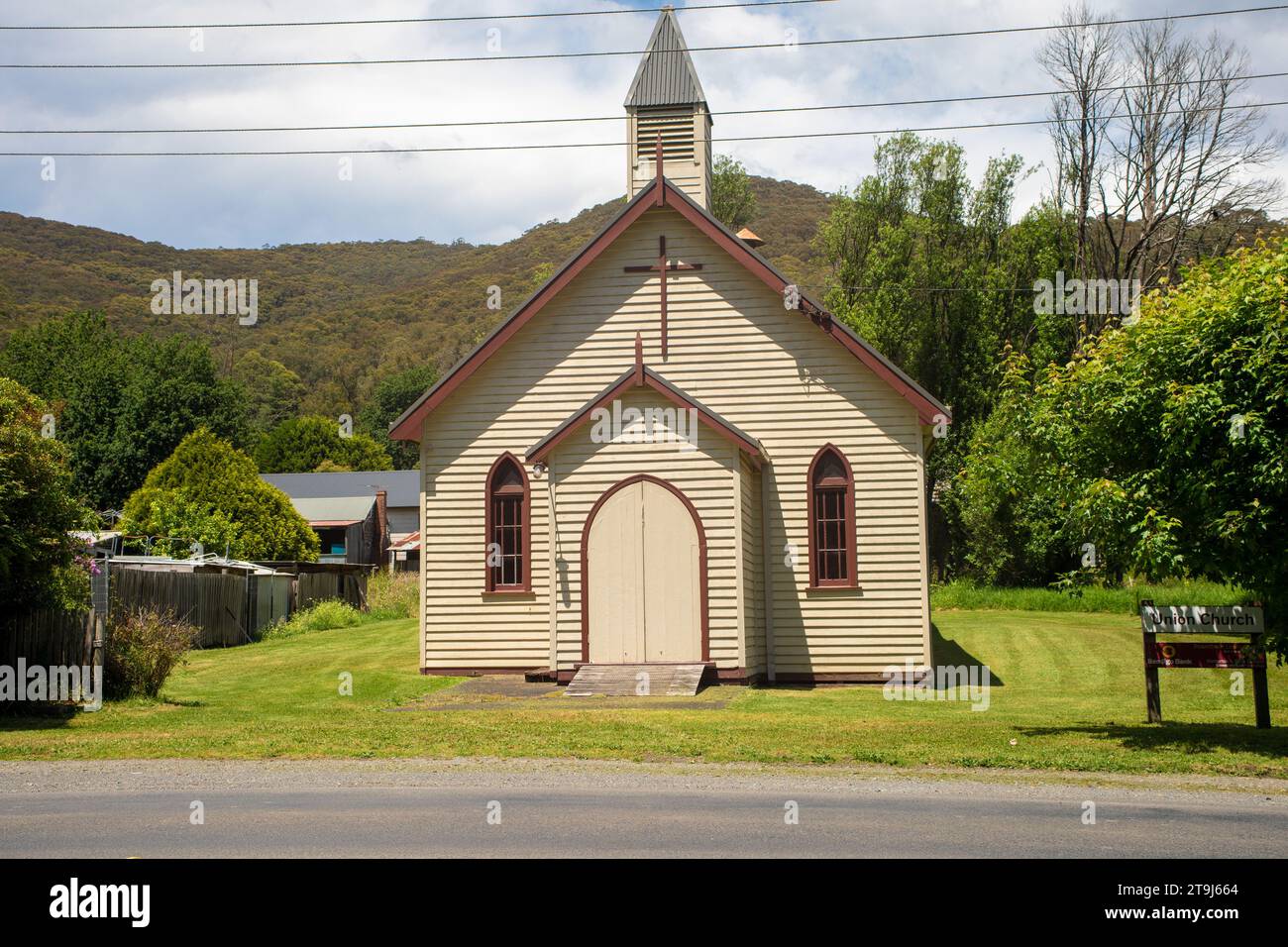 Powelltown, Victoria, Australien - 25. November 2023: Union Church in hellem Sonnenlicht mit Hügeln im Hintergrund. Stockfoto