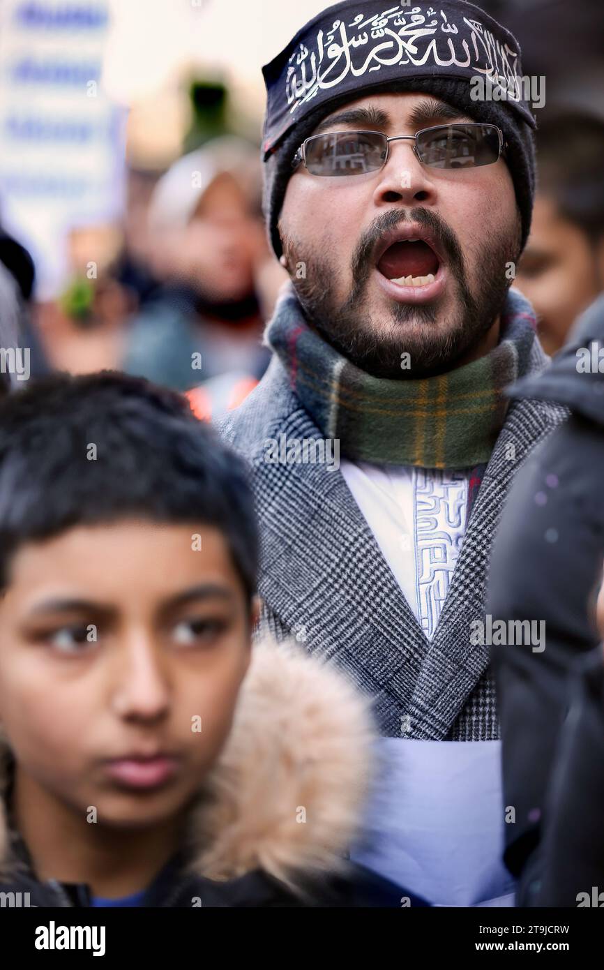 Ein Demonstrant trägt ein schwarzes Stirnband mit islamischer Schrift, während er als Reaktion auf Redner singt. Hizb ut-Tahrir protestierte gegenüber der ägyptischen Botschaft und rief muslimische Armeen zur Rettung des palästinensischen Volkes auf. Aufgrund der Bedingungen gemäß Abschnitt 14 des Public Order Act können sie Balfour Mews nicht verlassen. Hizb ut-Tahrir erklärt sein Ziel, alle muslimischen Länder im Laufe der Zeit in einem einheitlichen islamischen Staat oder Kalifat zu vereinigen und die Scharia weltweit zu implementieren. Hizb ut-Tahrir protestierte gegenüber der ägyptischen Botschaft und rief muslimische Armeen zur Rettung des palästinensischen Volkes auf. Conditio Stockfoto