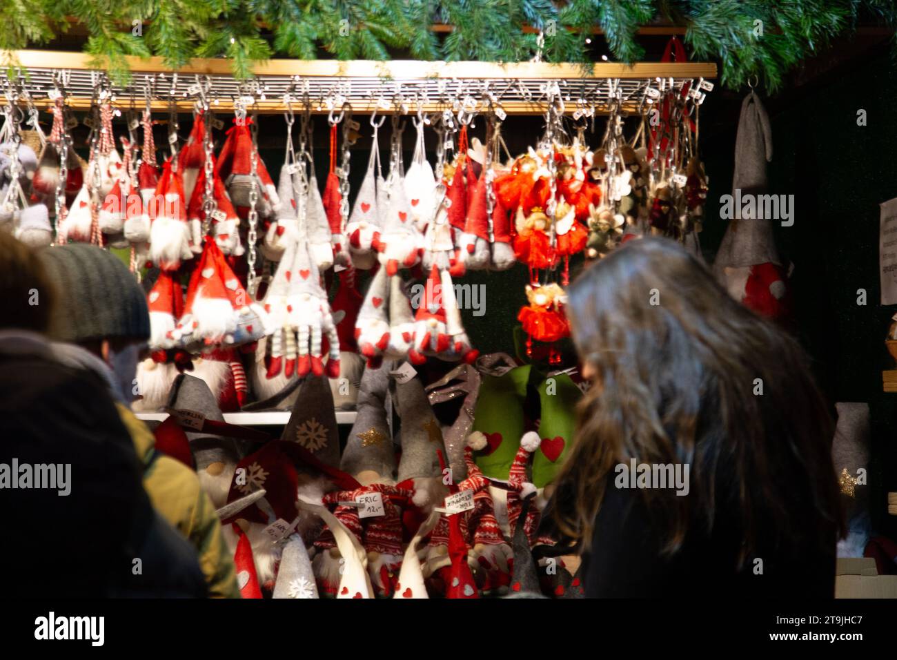 Straßenverkäufer verkaufen Weihnachtsschmuck und überfüllte Besucher am Wiener Christkindlmarkt in der Nacht im Winter in Wien Stockfoto