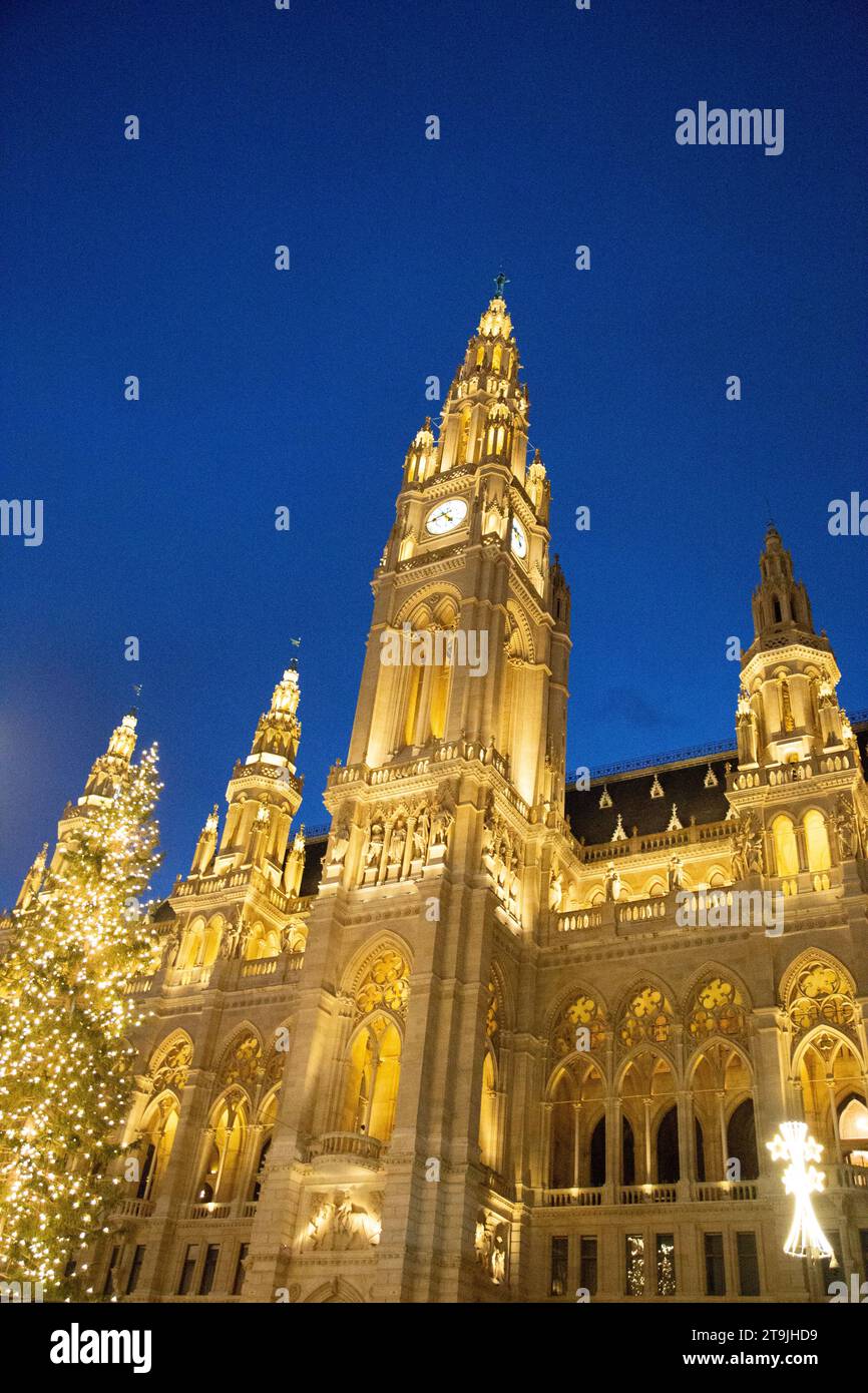 Das Rathause ist mit goldenen Nachtlichtern dekoriert, dessen Vorhof im Winter nachts als Wiener Christkindlmarkt genutzt wird Stockfoto