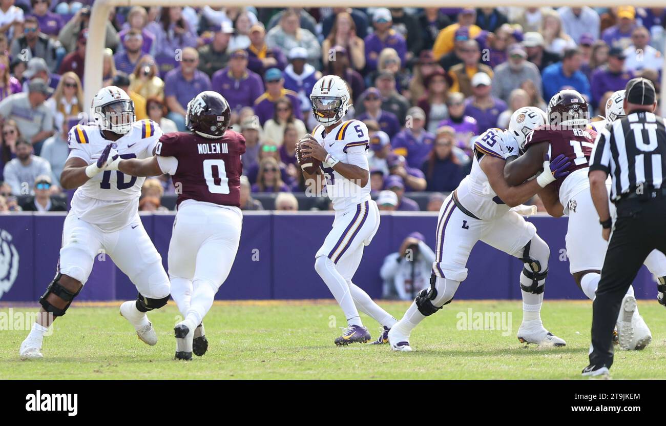 Baton Rouge, USA. November 2023. LSU Tigers Quarterback Jayden Daniels (5) sucht nach einem offenen Empfänger, während LSU Tigers Offensive Linemen Miles Frazier (70) und Charles Turner III (69) beide Texas A&M Aggies Defensive Linemen Walter Nolen (0) und Albert Regis (17) während eines Southeastern Conference Football-Spiels im Tiger Stadium in Baton blockieren Rouge, Louisiana am Samstag, 25. November 2023. (Foto: Peter G. Forest/SIPA USA) Credit: SIPA USA/Alamy Live News Stockfoto