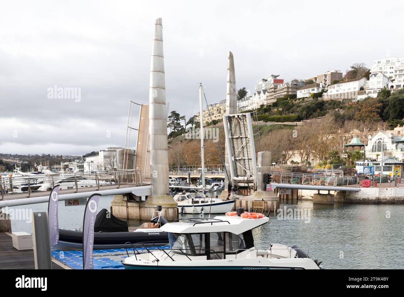 Eine Yacht, die durch die 2003 Doppelkupplungsbrücke im Torquay Harbour fährt, die den Nord- und Südpier zum ersten Mal vollständig geöffnet verbindet. Stockfoto