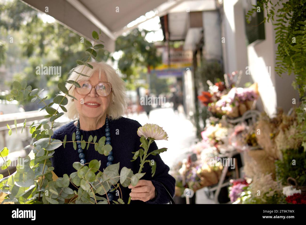 Eine ältere Frau kauft Blumen in einem Blumengeschäft Stockfoto