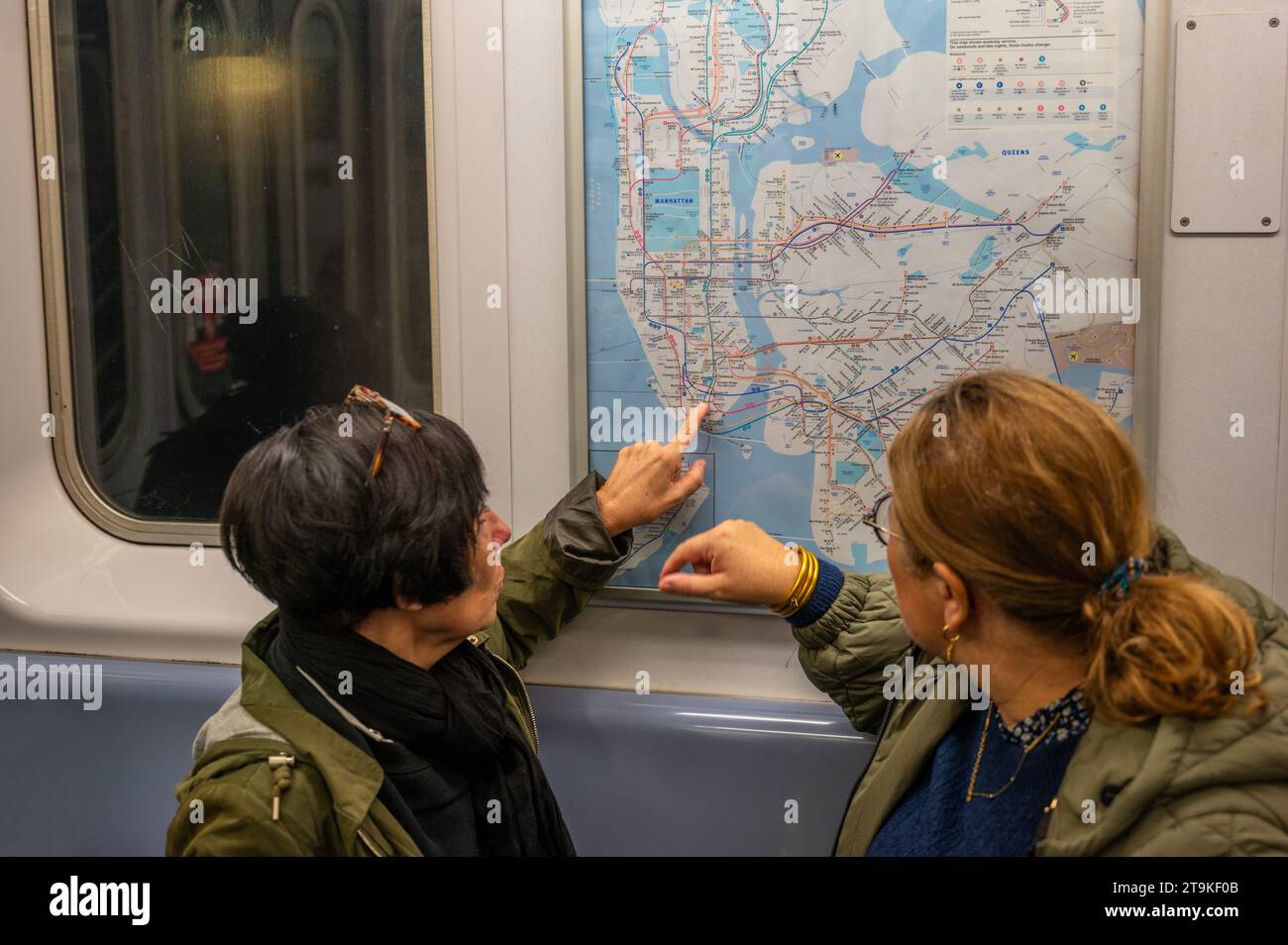 2 New yorker U-Bahn-Passagiere sehen sich eine Karte an Stockfoto