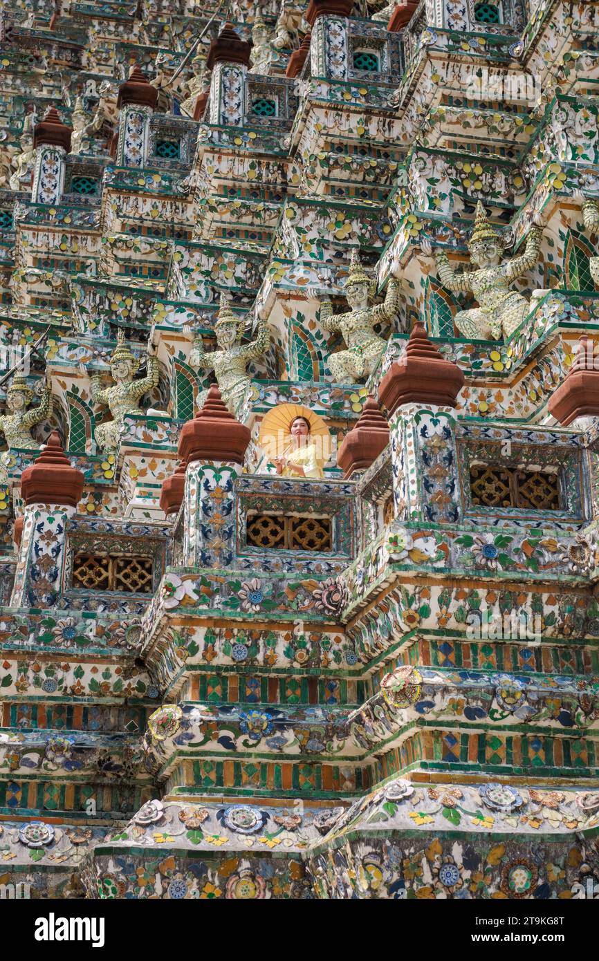 Asiatische Touristen in der traditionellen thailändischen Tracht stehen und fotografieren auf der Pagode im Wat Arun Ratchawararam Ratchawaramahawihan. Stockfoto