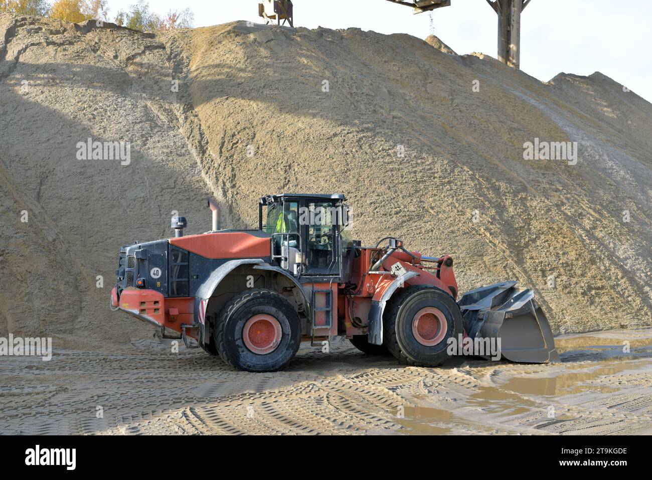 Radlader beladen Lkw mit Kies in einer Sandgrube – Transport und Abbau von Baustoffen für die Bauindustrie Stockfoto