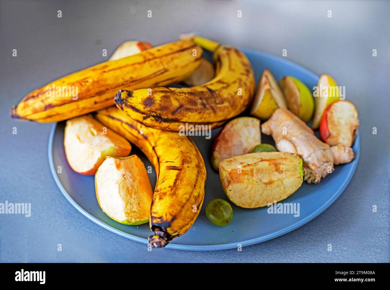 Teller mit Bananen und Äpfeln auf der Theke von oben Stockfoto