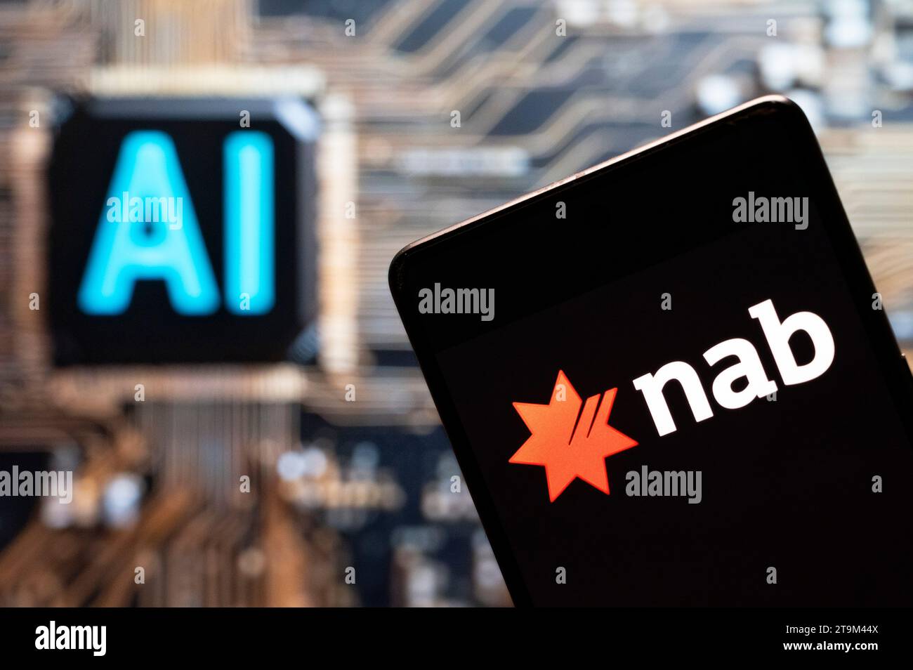 In dieser Fotoabbildung wird das Logo der National Australia Bank (NAB) auf einem Smartphone mit einem Chip für künstliche Intelligenz (KI) und einem Symbol im Hintergrund angezeigt. Stockfoto