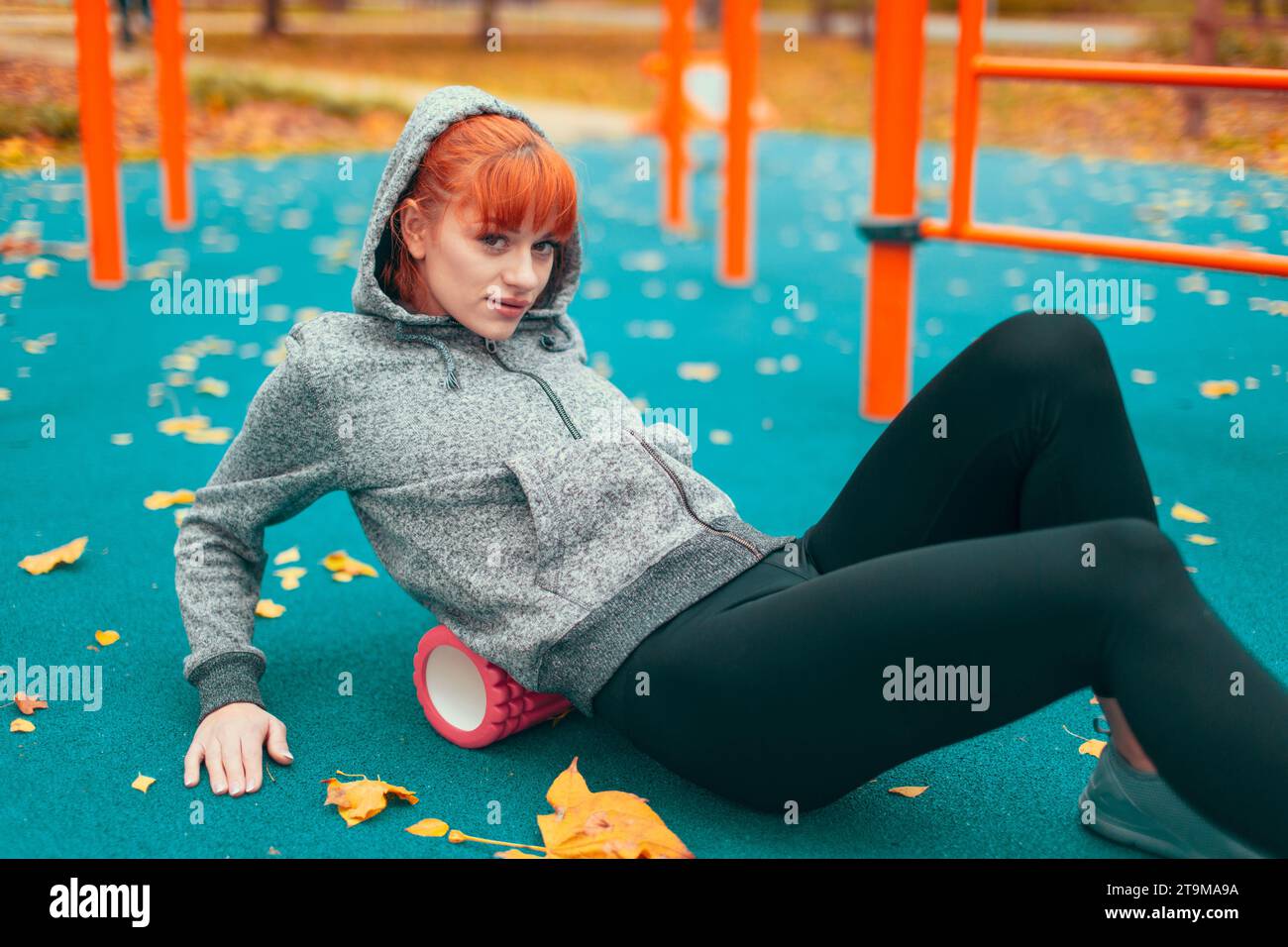Junge kaukasische Stadtfrau mit Schaumwalze im Herbst im Park Stockfoto