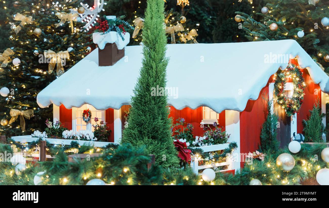 Ein Miniatur-Bauernhof mit weihnachtlichen Elementen, darunter ein kleiner Baum und ein Weihnachtslicht mit Kerzenlicht Stockfoto