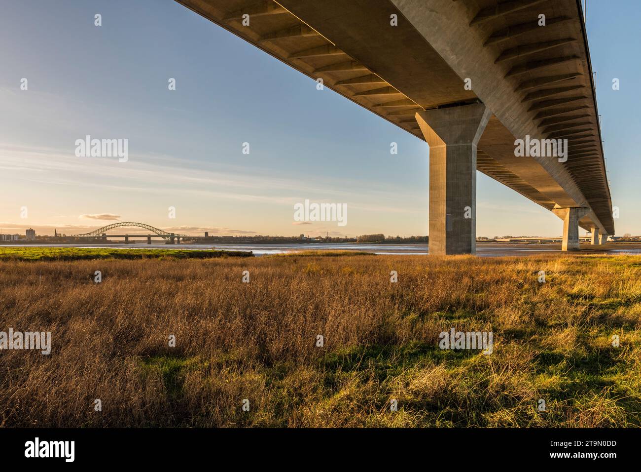 Ein Blick unter der Mersey Gateway Bridge, die den Mersey River und den Manchester Ship Canal überquert, mit der Silver Jubilee Bridge dahinter Stockfoto