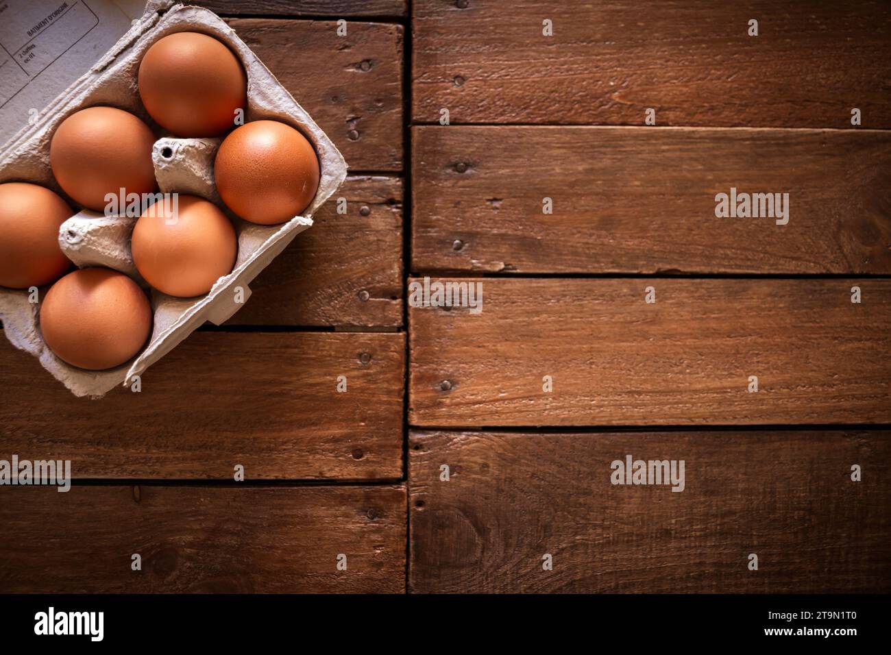 Frische Eierkarton auf rustikalem Holzbrett Hintergrund Stockfoto