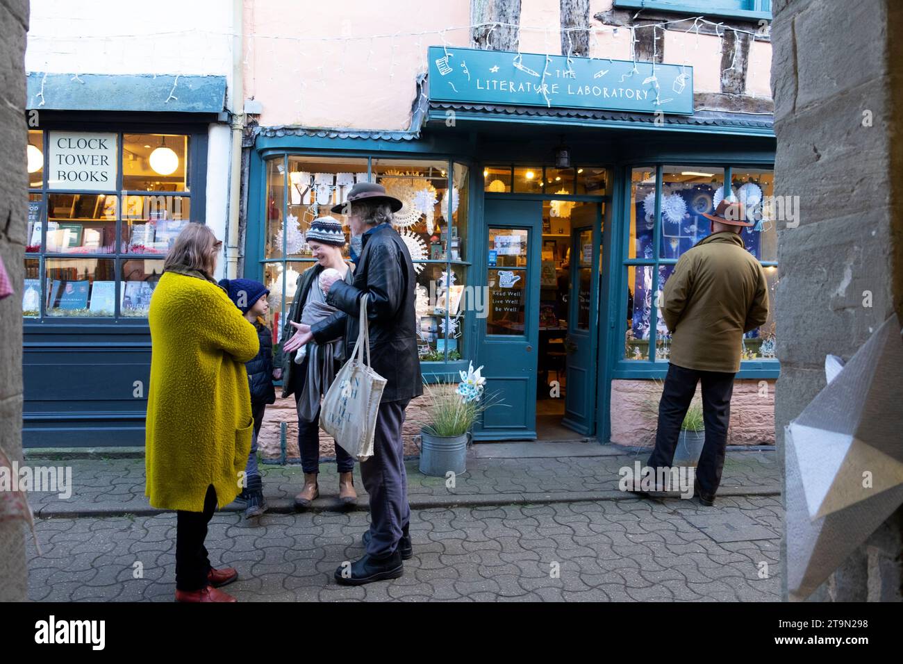 Leute Freunde unterhalten sich vor den Geschäften der Stadt Hay-on-Wye im Christimas während des Hay Winter Festival Buchfestivals in Wales, Großbritannien KATHY DEWITT Stockfoto