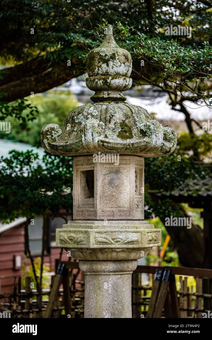 Eine japanische Ishi-doro Steinlaterne in Japan und Bäume im Hintergrund Stockfoto