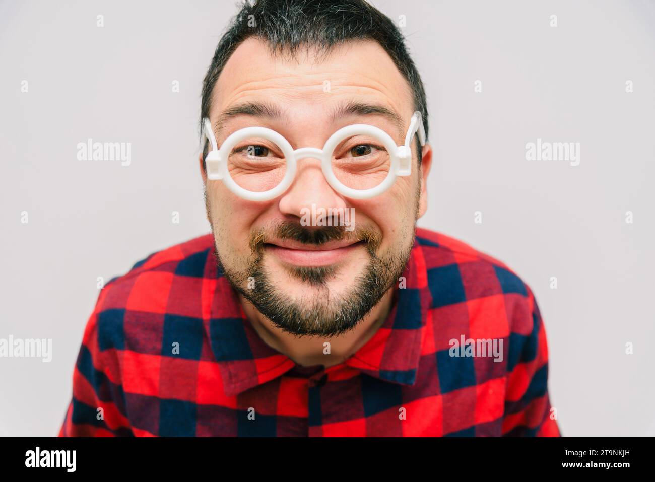 Lustiges Porträt eines Mannes mit Brille. Fröhliche bärtige Wissenschaftsfreaks, die aus nächster Nähe in die Kamera schauen. Сomic Nerd Nahaufnahme Porträt. Stockfoto