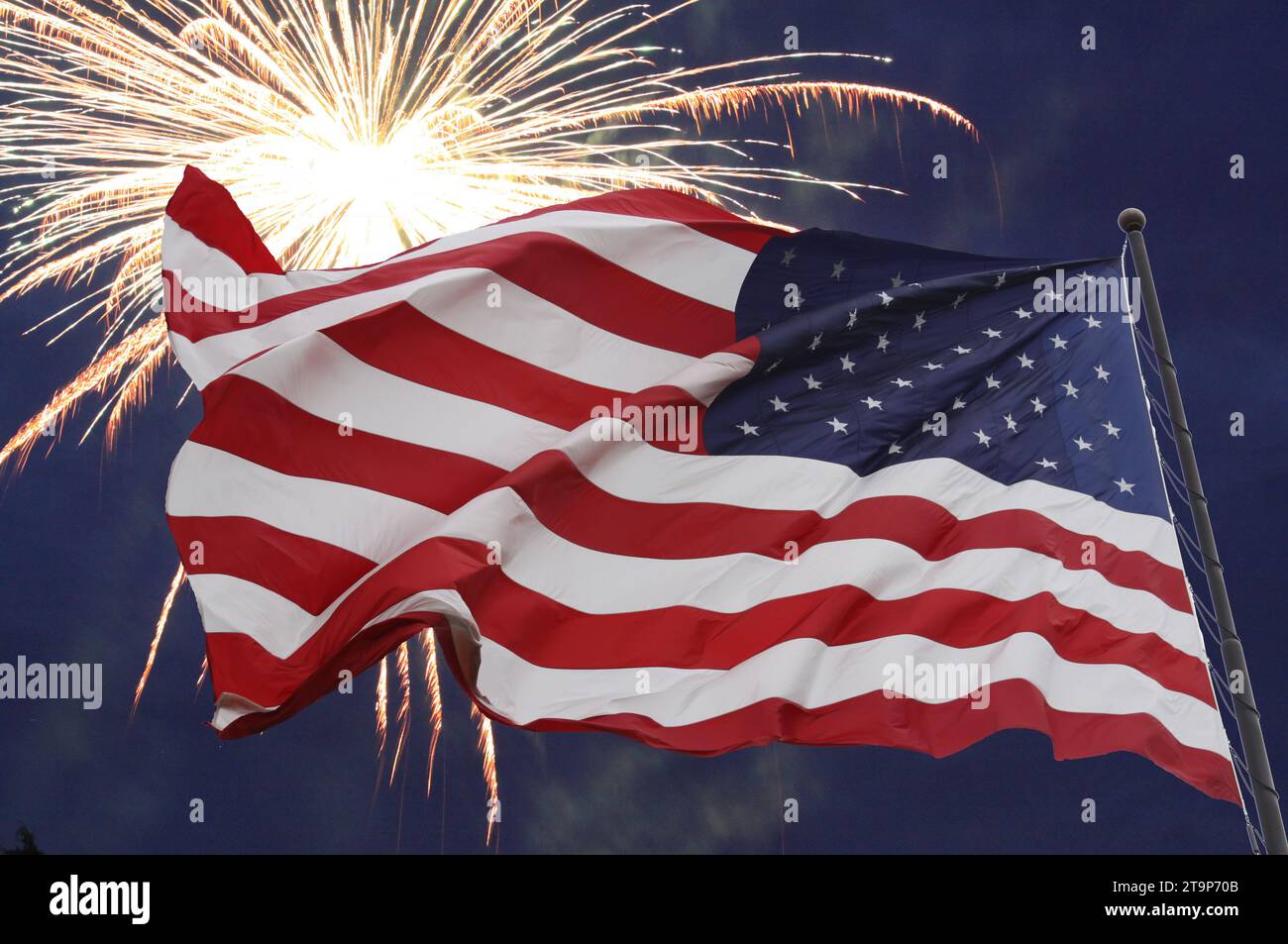 4. Juli: Feuerwerk hinter der rot-weißen und blauen US-Flagge. Stockfoto