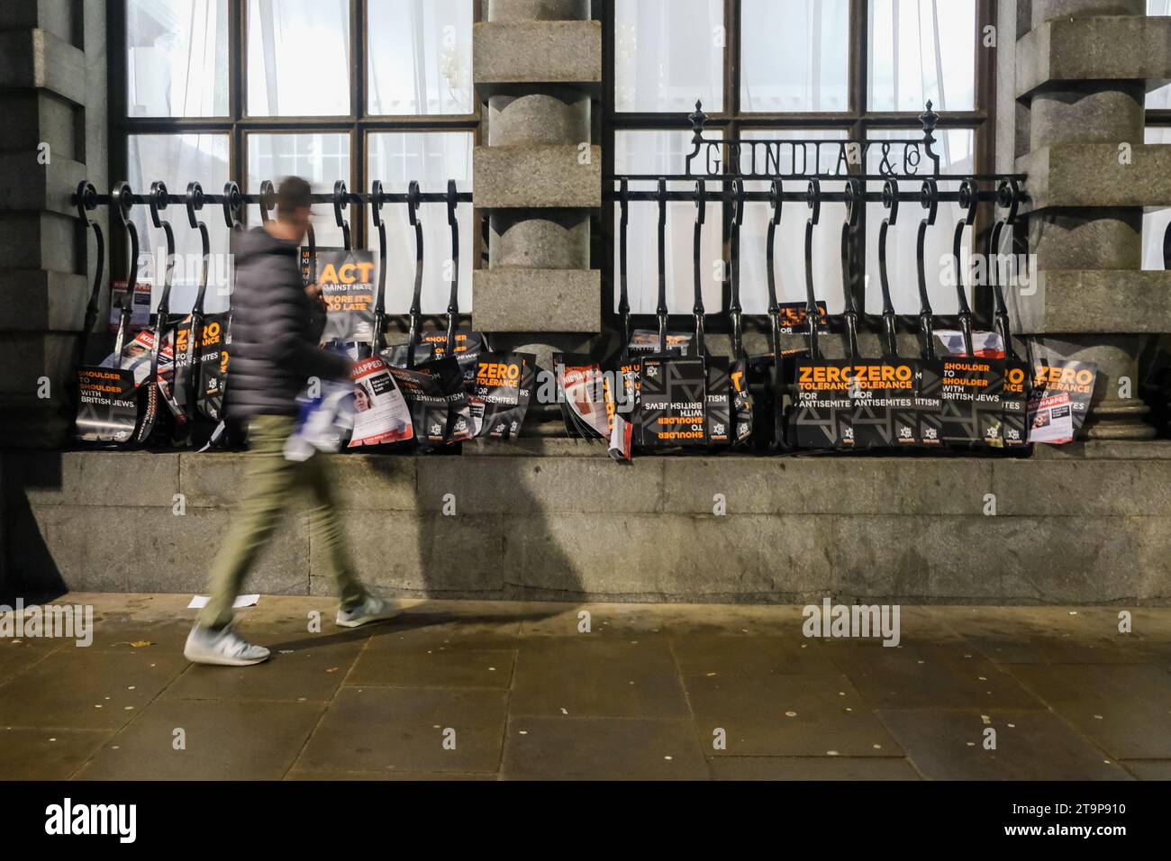 London, Großbritannien. November 2023. Ein Mann geht an weggeworfenen Plakaten und Schildern vorbei, während der Marsch gegen den Antisemitismus im Zentrum Londons endet. Zehntausende nahmen an der Demonstration Teil, marschierten von den königlichen Gerichten bis zum Parlamentsplatz. Die Kundgebung gilt als die größte ihrer Art seit der Schlacht an der Cable Street im Jahr 1936. Quelle: Eleventh Photography/Alamy Live News Stockfoto