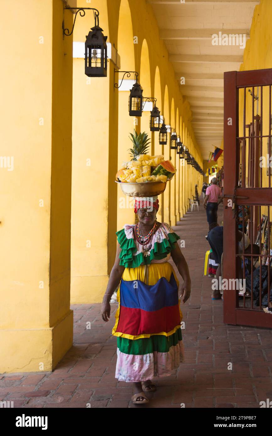 Eine Palenquera, oder Obstverkäufer aus der Stadt Palenque, blitzt mit ihrem bunten Outfit in Cartagena de Indias, Kolumbien, durch die Straßen Stockfoto