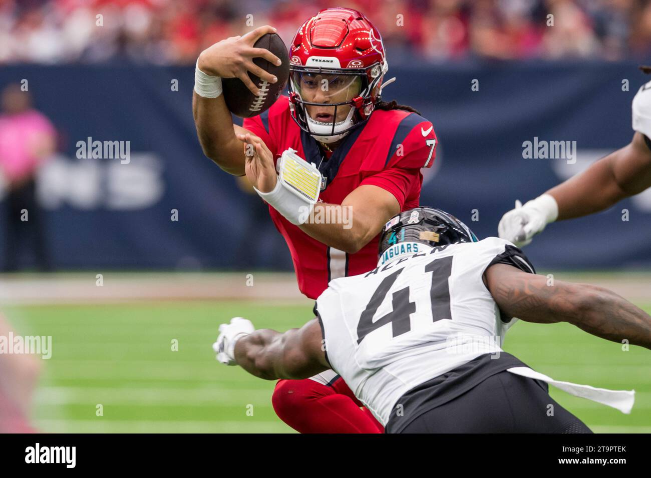 Houston, Texas, USA. 26. November 2023: Der Houston Texans Quarterback C.J. Stroud (7) kämpft um die Yardage, als der Jacksonville Jaguars Linebacker Josh Allen (41) in Houston, Texas, ein Tackle macht. Trask Smith/CSM Credit: CAL Sport Media/Alamy Live News Stockfoto