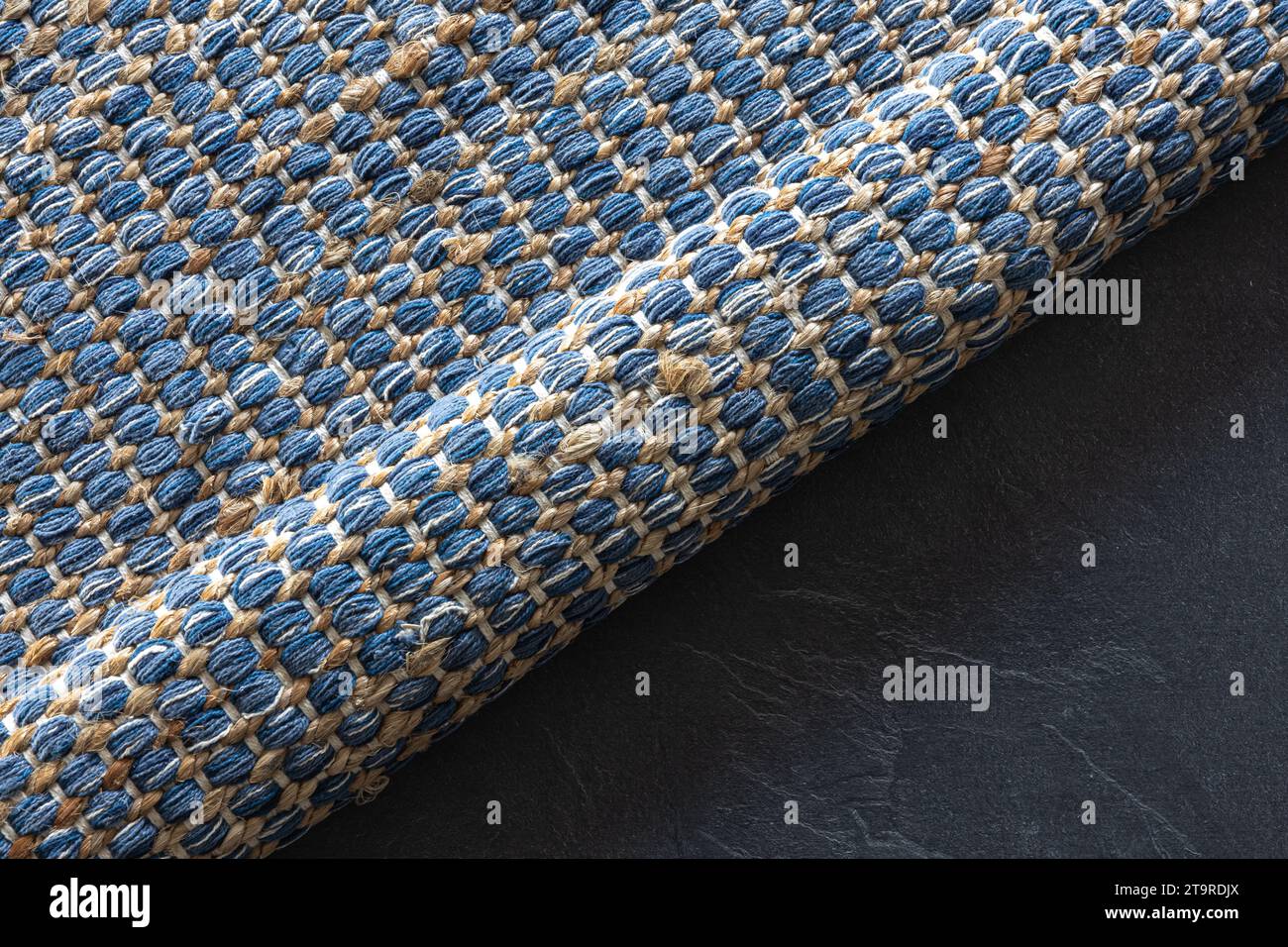 Handgewebter Teppich mit geometrischem Denim-Bereich auf schwarzem Boden. Stockfoto