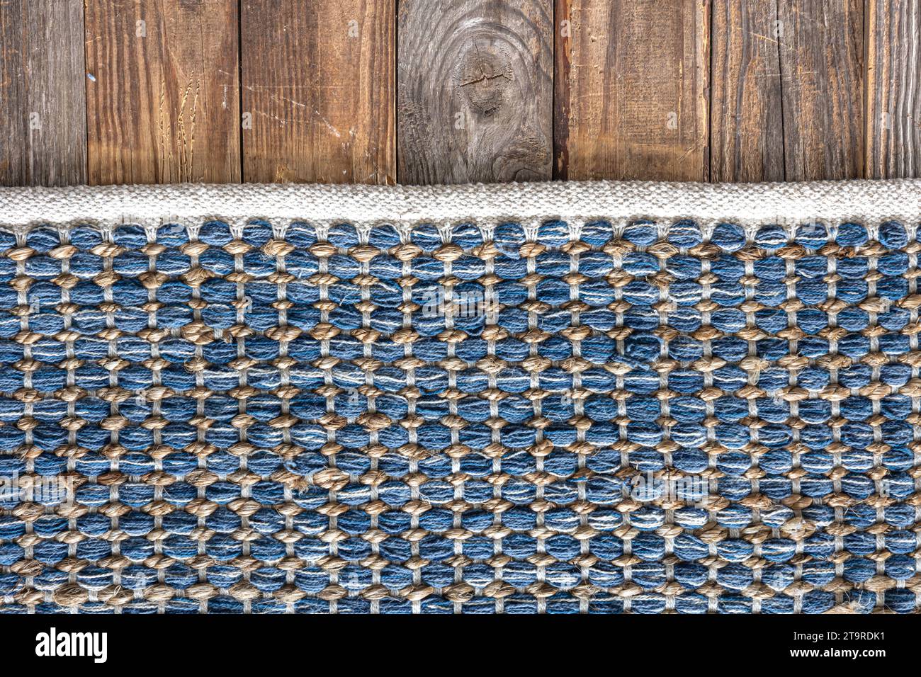 Handgewebter Teppich mit geometrischem Denim-Bereich auf Holzboden. Stockfoto