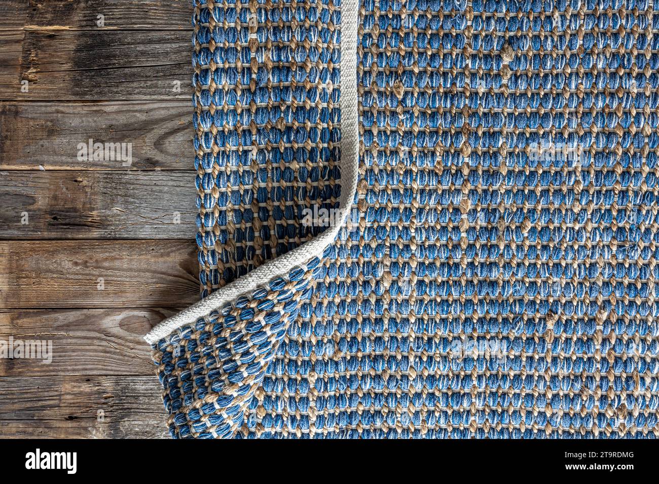 Handgewebter Teppich mit geometrischem Denim-Bereich, geflochtene Jute-Hintergrundstruktur. Stockfoto
