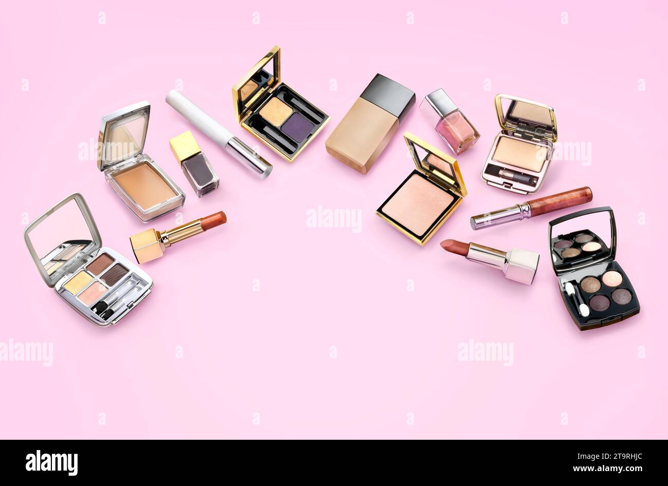 Unterschiedliche Arten von Make-up-Einstellungen vor rosafarbenem Hintergrund. Lippenstift, nagellack, Lidschatten, Gesichtspuder. Stockfoto