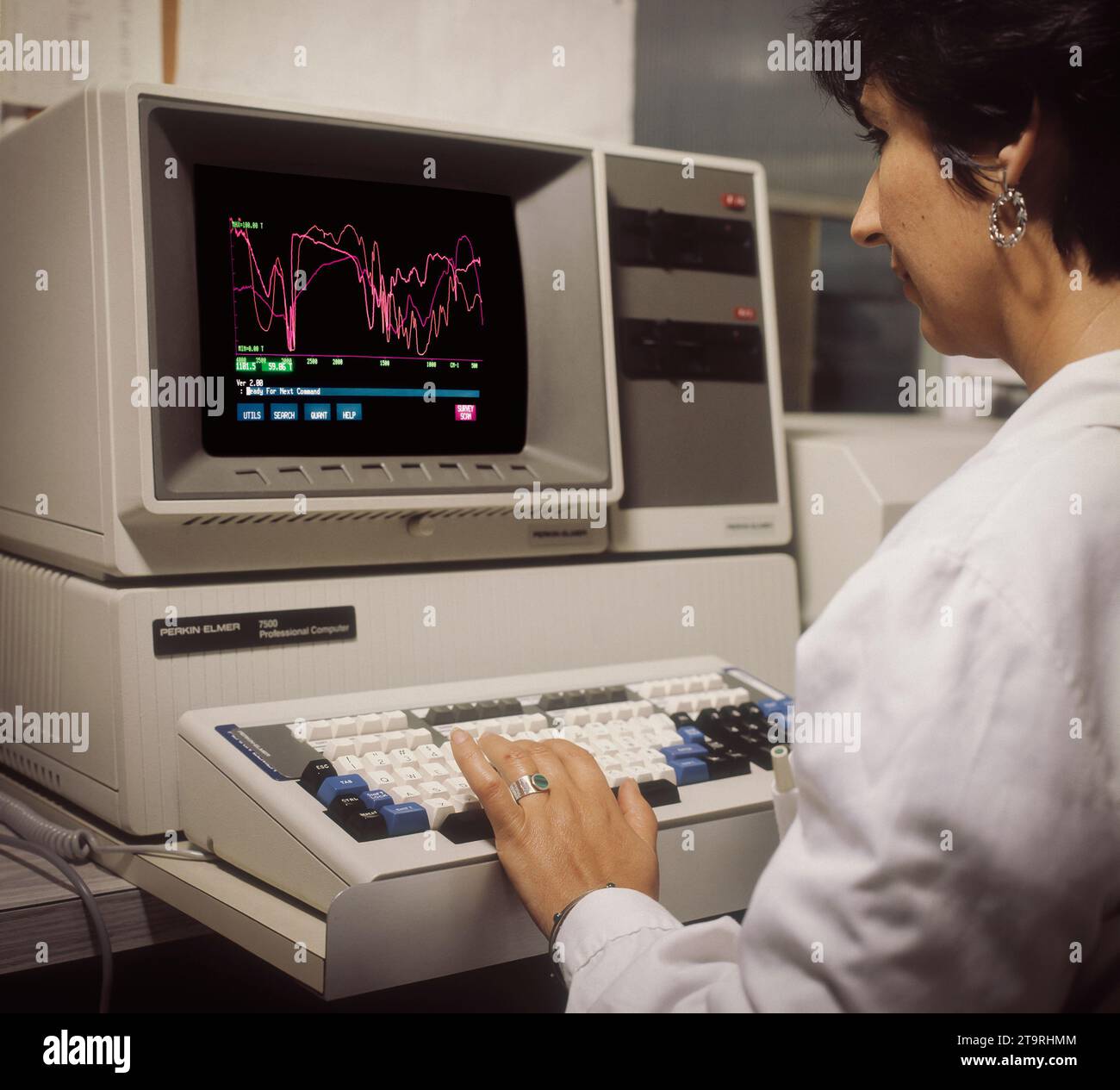 Barcelona- Spanien- Ca. 1987. Archivbild. Scannen analoge Fotografie einer Wissenschaftlerin, die einen alten Computer PerkinElmer 7500 bedient Stockfoto
