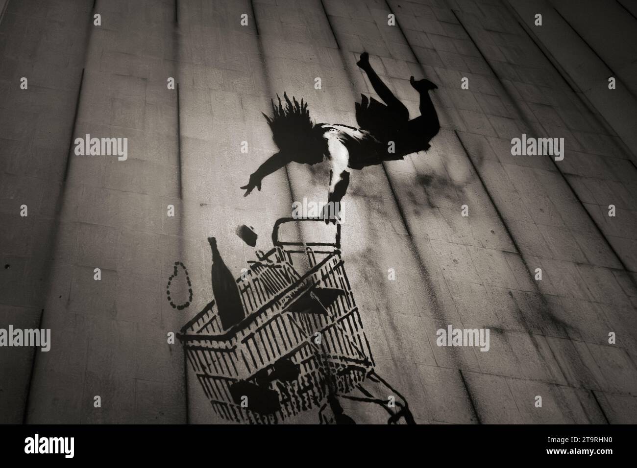Barcelona - Spanien Ca. Februar 2022. Banksy-Graffiti-Poster auf der Banksy-Ausstellung in Barcelona. Banksy Falling Shopper. Shoppen Sie bis zum Umfallen. Stockfoto