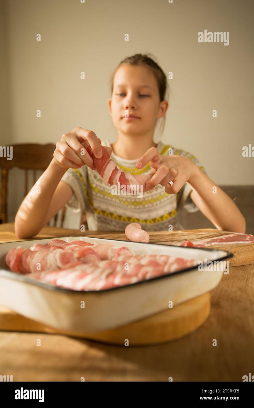 Ein Mädchen bereitet ein traditionelles Weihnachtsgericht zu, „Schweine ...