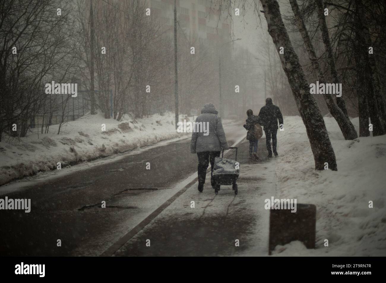 Die Leute laufen die Winterstraße entlang. Stockfoto