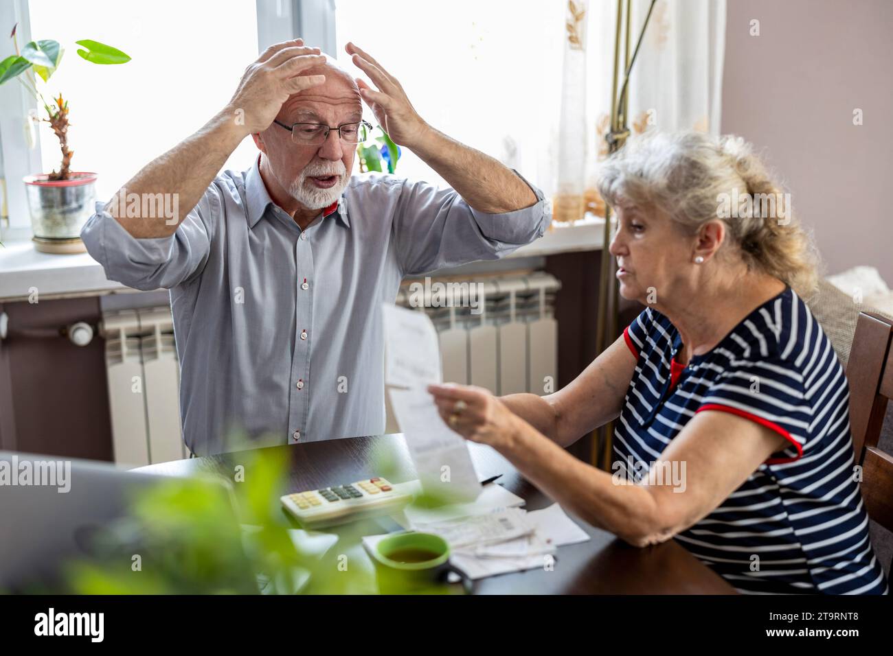 Seniorenpaar diskutieren ihre Finanzen, während sie am Tisch sitzen Stockfoto