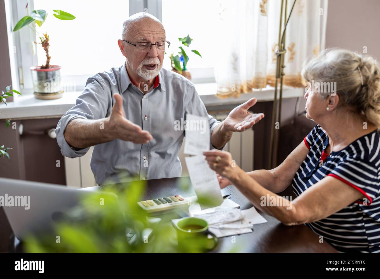 Seniorenpaar diskutieren ihre Finanzen, während sie am Tisch sitzen Stockfoto