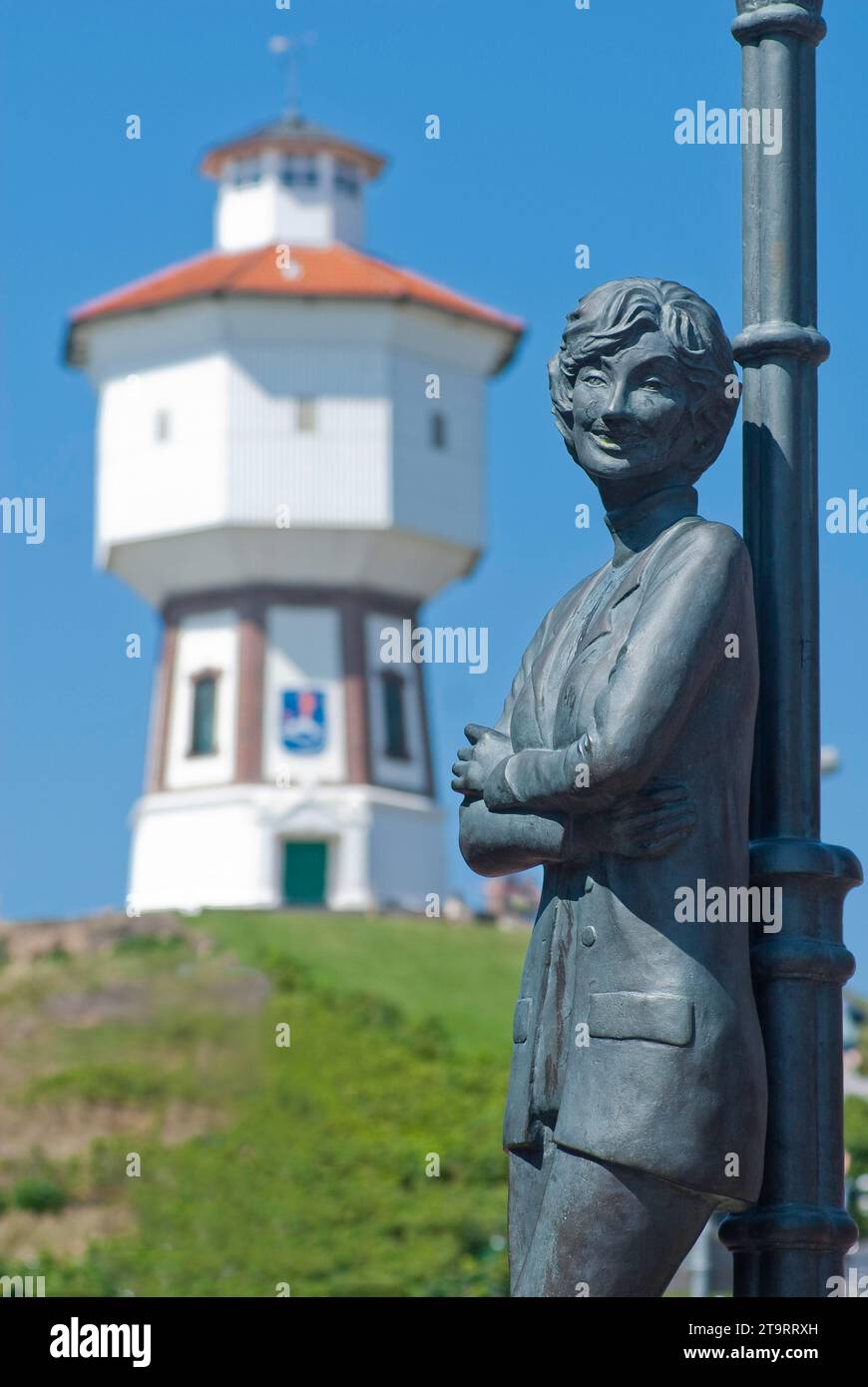 Die Statue von Lale Andersen (Lili Marleen) mit dem Wasserturm auf der Nordseeinsel Langeoog, Deutschland Stockfoto
