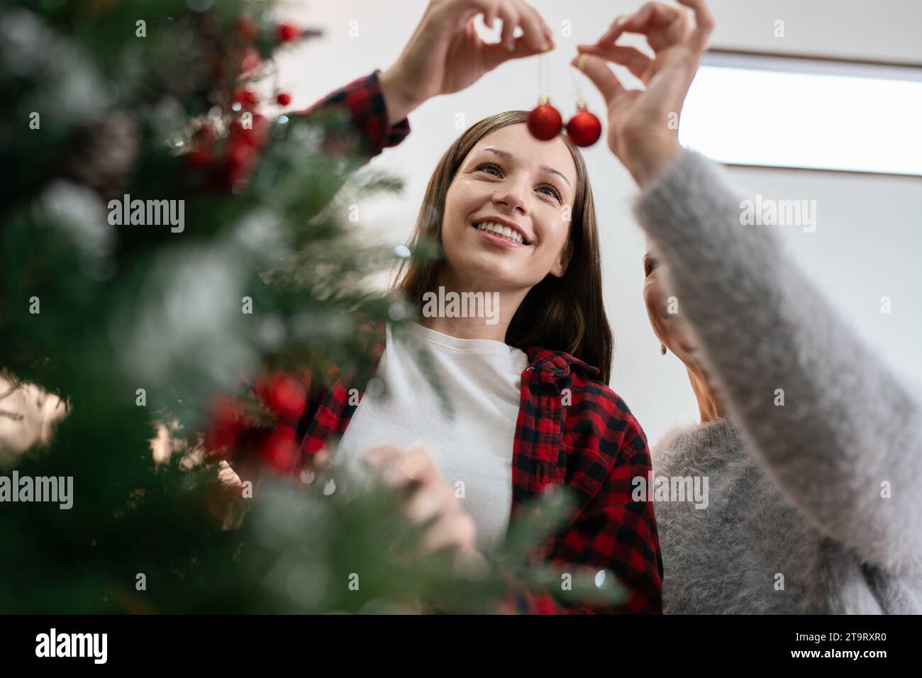 Frau dekoriere zu Weihnachten zu Hause. Die Familie feiert zu Hause ein glückliches neues Jahr Stockfoto